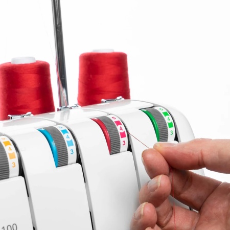 Husqvarna Amber S|100 compact overlocker with thread cones in place and showing tension dials.