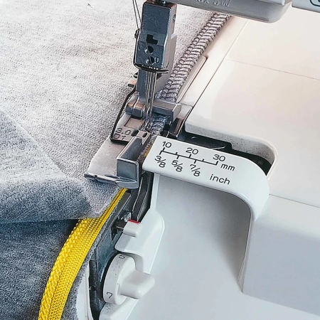 Close-up of the Huskylock S21 overlocking some fabrics.