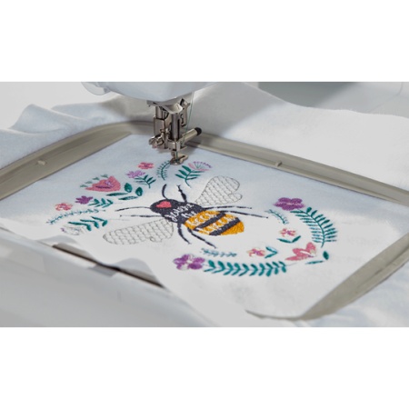 Bee embroidery design in the hoop of the embroidery unit.