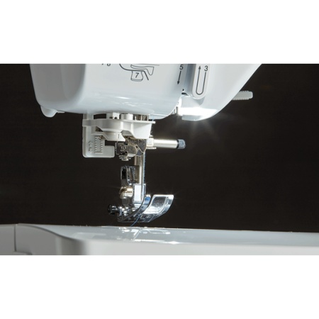 Sewing machine foot are, showing bright lcd light and automatic needle threader.