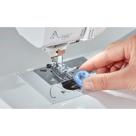 Close up of a bobbin being put in the drop in bobbin case
