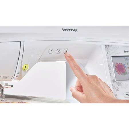 Close up of the Brother NV880E, showing the start/stop button and stitch buttons on the front.