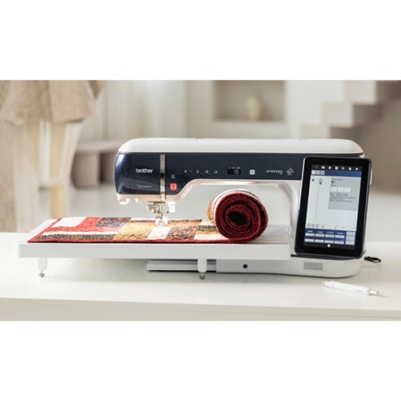 Brother EV1 on a table with a quilt rolled up on the sewing bed