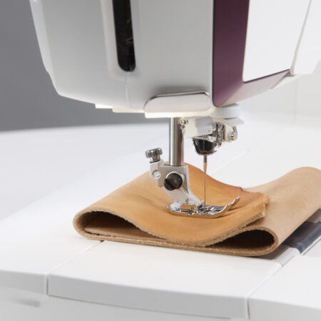 Close up shot of the Designer Topaz 65 sewing and embroidery machine sewing thick layer of fabric