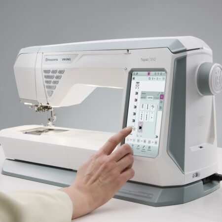 Husqvarna Viking Designer Topaz 55Q sewing machine on a table, touch screen display